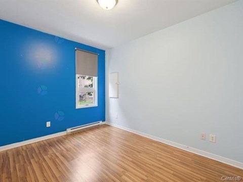 A room with a blue wall and a wooden floor.