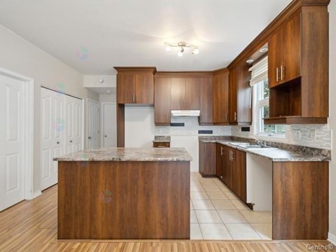 A kitchen with wooden cabinets and a marble countertop.