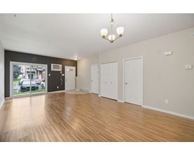 A spacious room with wooden flooring and white walls.