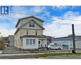 A two-story house with a car parked in front.