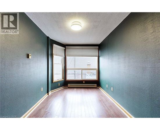 A hallway with a window and a wooden floor.