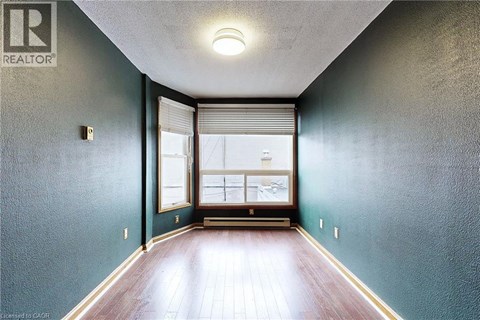 A hallway with a window and a wooden floor.