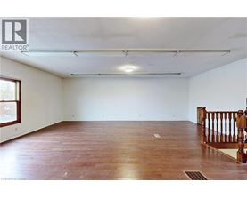 A spacious room with wooden flooring and white walls.