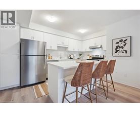 A kitchen with white cabinets and a stainless steel refrigerator.