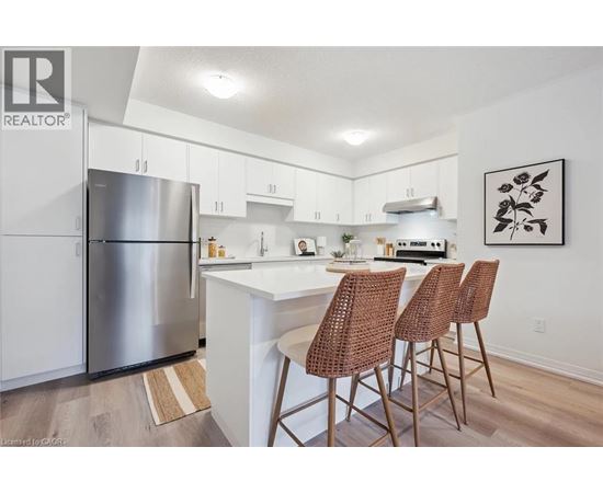 A kitchen with white cabinets and a stainless steel refrigerator.