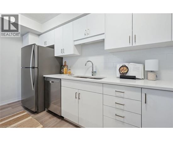 A modern kitchen with white cabinets and a stainless steel refrigerator.