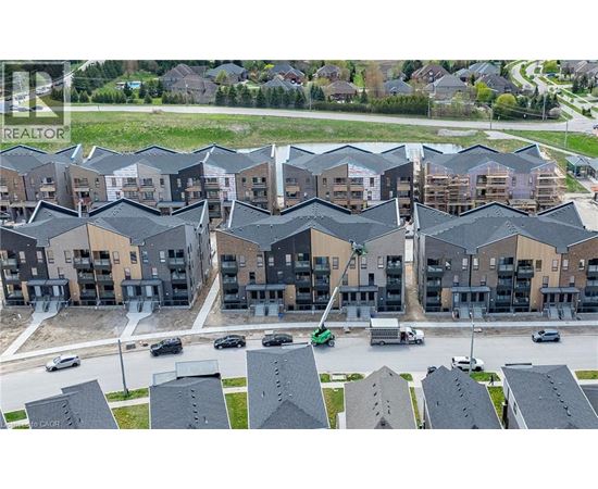 A large apartment complex with multiple buildings and cars parked in the driveways.