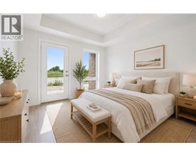 A bedroom with a large bed, a bench, and a window with a view of the outdoors.