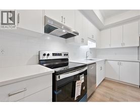 A modern kitchen with white cabinets and a black stove top oven.