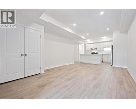 A spacious room with wooden flooring and white walls.