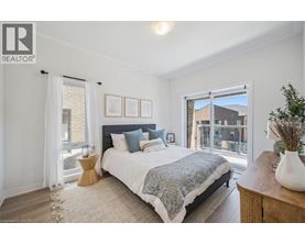 A bedroom with a large bed and a view of a balcony.