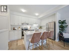 A kitchen with white cabinets and a wooden floor.