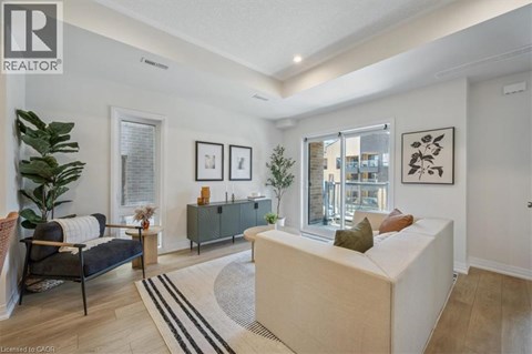 A living room with a sofa, a chair, a rug and pictures on the wall.