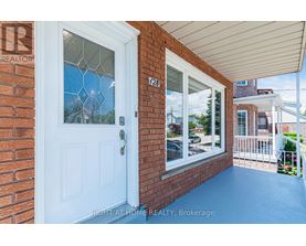 A white door with a glass window is on a brick wall.