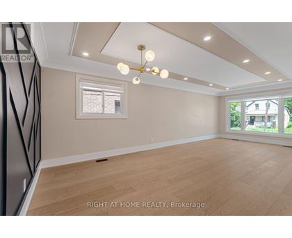 A well-lit room with a window and wooden flooring.