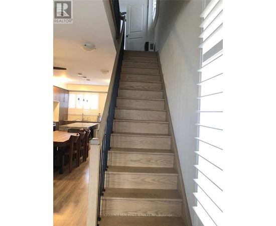 A wooden staircase with a black railing.