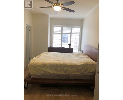 A bedroom with a bed, a ceiling fan, and a window with blinds.