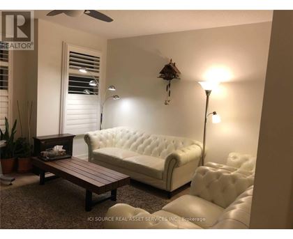 A white tufted couch sits in a living room with a wooden coffee table in front of it.