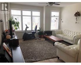 A living room with a white couch, a brown coffee table, and a ceiling fan.