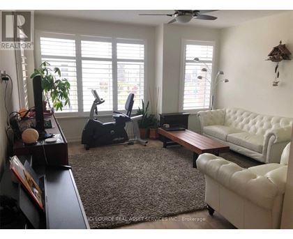 A living room with a white couch, a brown coffee table, and a ceiling fan.
