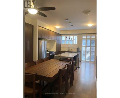 A kitchen with a table and chairs in front of a window.