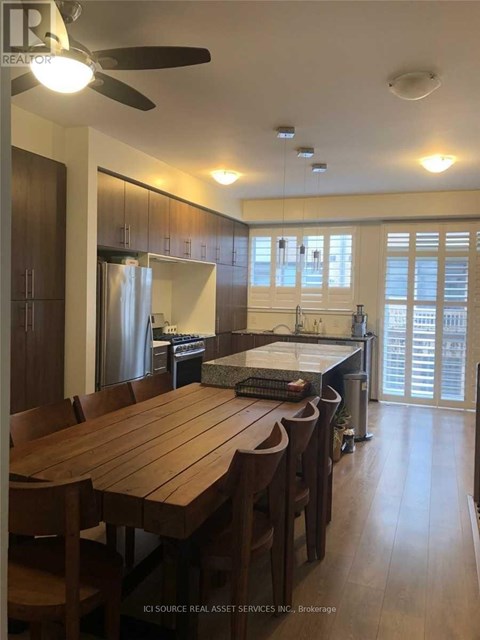 A kitchen with a table and chairs in front of a window.