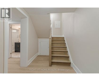 A staircase in a house with a white wall and a light switch.
