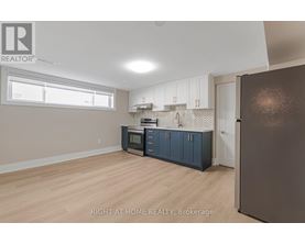 A kitchen with a refrigerator, cabinets, and a microwave.