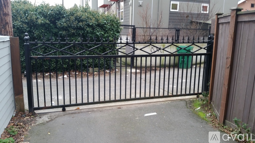 A black metal gate with a green sign on it.