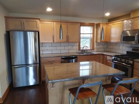 A kitchen with a table and chairs in front of a refrigerator.
