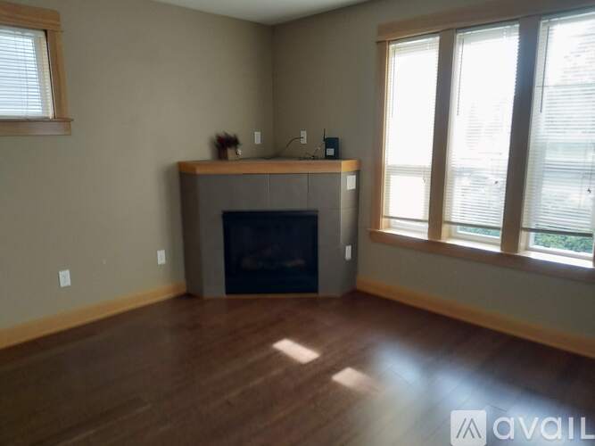 A living room with a fireplace and wood flooring.