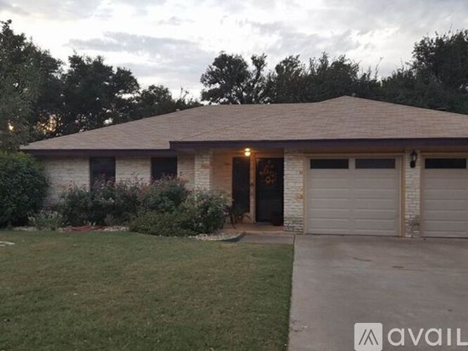 A house with a brown roof and a garage door is available for rent.