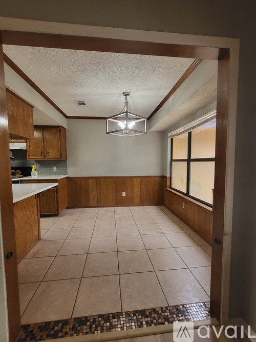 A kitchen with brown cabinets and a tiled floor.