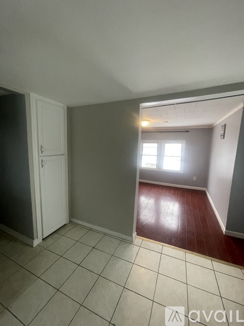 A room with a door, a window, and a tiled floor.