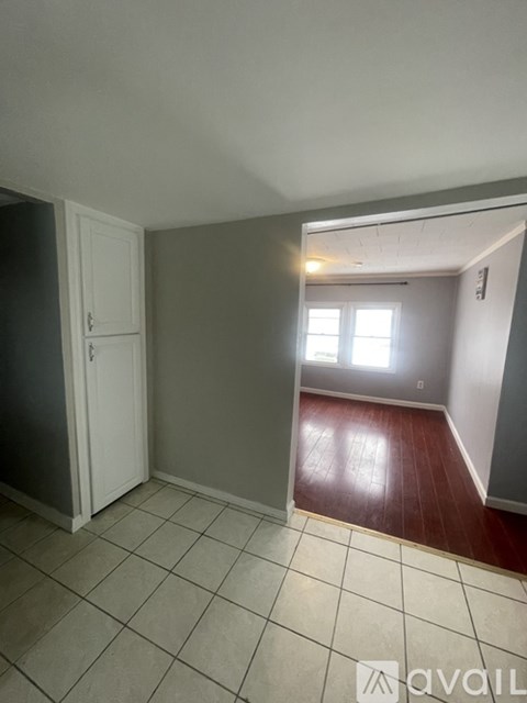 A room with a door, a window, and a tiled floor.