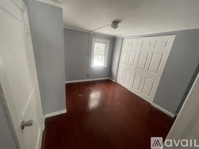 A room with a wooden floor and a white door.