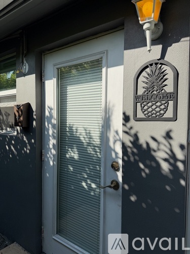 A white door with a pineapple design on the wall above it.