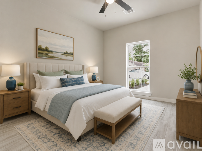 A bedroom with a large bed, a bench, and a painting on the wall.