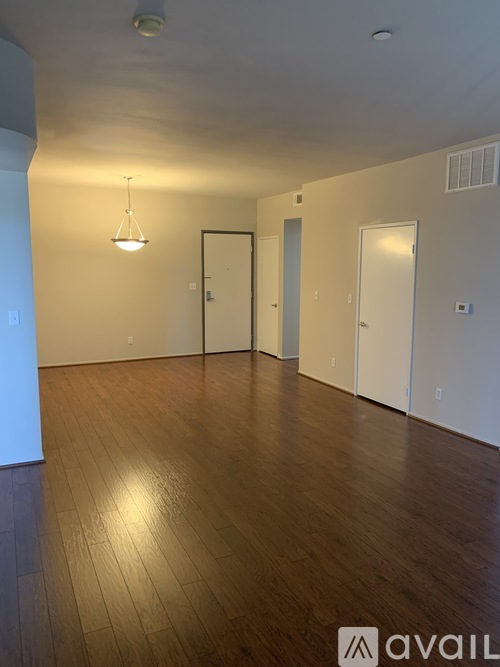A room with wooden floors and three doors.
