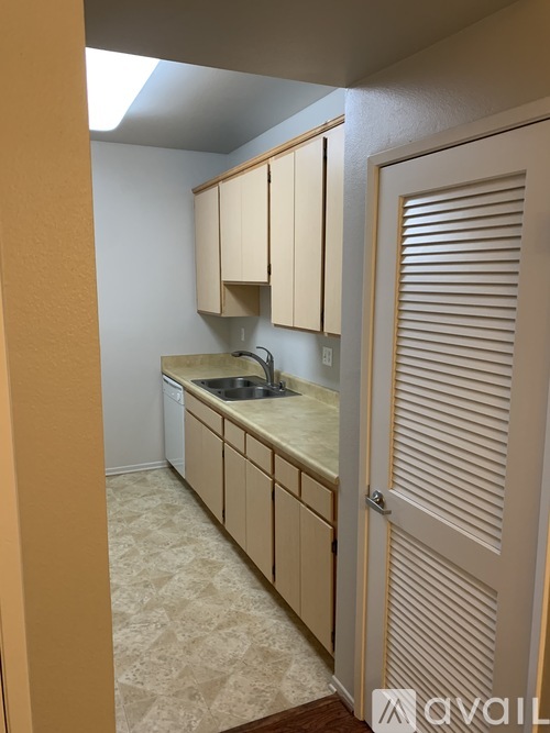 A kitchen with beige cabinets and a sink.