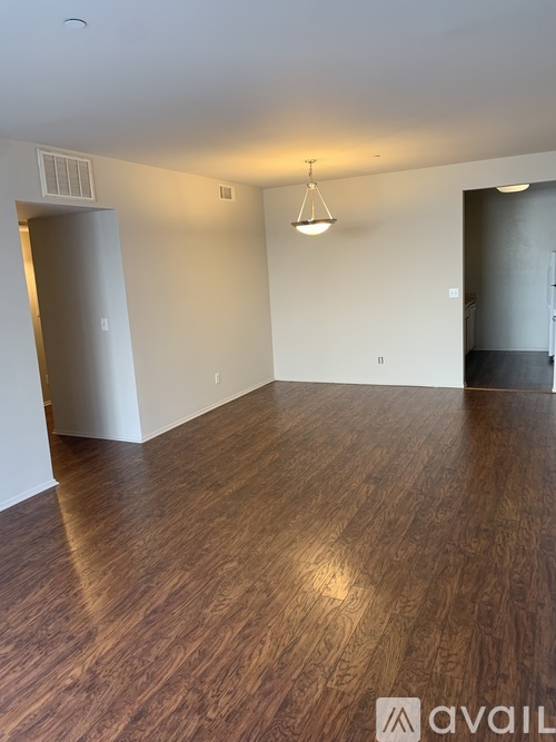 A room with wooden flooring and a pendant light hanging from the ceiling.