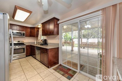 A kitchen with brown cabinets and a refrigerator.
