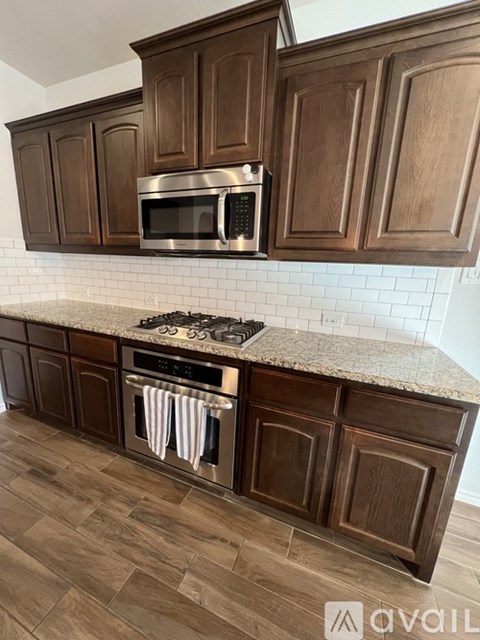 A kitchen with wooden cabinets and a granite countertop.
