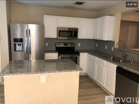 A kitchen with a granite countertop and stainless steel appliances.