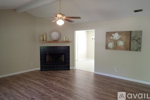 A living room with a fireplace and a painting on the wall.