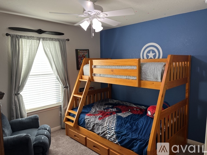 A bedroom with a bunk bed and a chair.