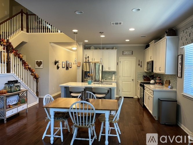 A kitchen with a table and chairs in front of it.