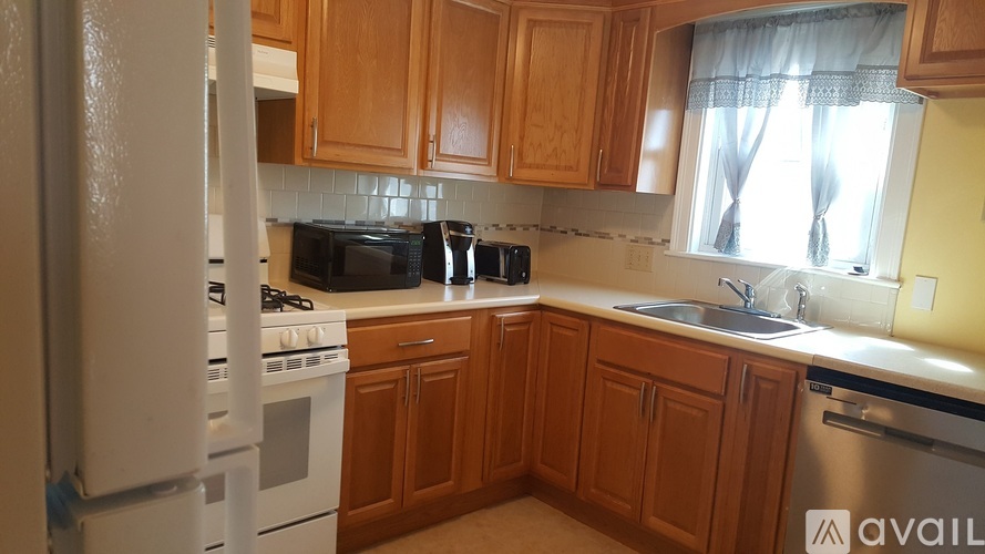 A kitchen with wooden cabinets and a white refrigerator.