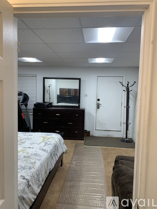 A bedroom with a bed, dresser, and mirror.