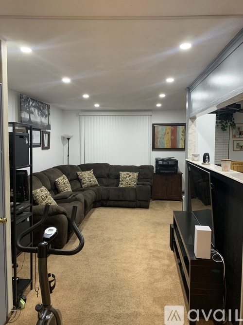 A living room with a dark brown couch and a television.